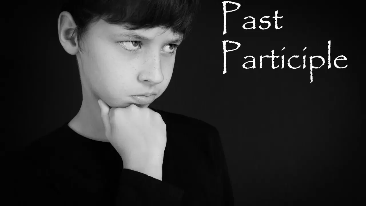 Chłopiec zamyślony, z podpartą brodą, jakby zastanawiał się nad trudnym zadaniem, być może nad gramatyką i formą **czas past participle**.