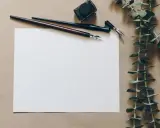 Eleganckie pióra i kałamarz na papierze, gotowe do napisania listu formalnego.